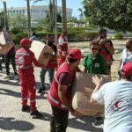 humanitarian aid workers handing out large boxes in the Gaza crisis